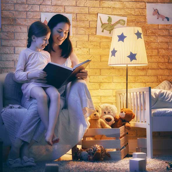 Mother and daughter reading by a lamp